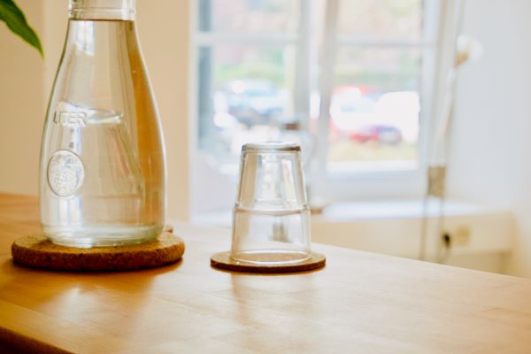 Empfangstheke der Praxis Besenbruch mit Wasser und Glas
